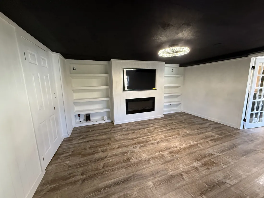 Completed GPF interior with painted white shelving, fireplace wall and contrasting black ceiling